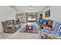 Bright living room with a ceiling fan, neutral carpet, cozy furniture, and a large sliding glass door to the backyard at 78 Zenith St, Port Charlotte, FL 33954