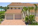 Charming coastal condo featuring private garages, brick driveway, lush landscaping, and beach access at 876 Golden Beach Blvd # 876, Venice, FL 34285