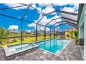 Relaxing backyard pool and spa offer waterfront views and an enclosed lanai, perfect for outdoor living at 13284 Amaryllis Cir, Port Charlotte, FL 33981