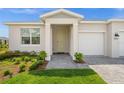 Inviting front entrance with stone pathway and landscaped garden, showcasing a charming home at 16440 Marsh Ln, Punta Gorda, FL 33982