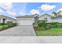 Well-maintained single-story home with lush landscaping, brick-paved driveway and attached two-car garage at 17620 Winding Wood Ln, Punta Gorda, FL 33982