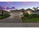 Charming single-story home with a brick-paved driveway and attached two-car garage, surrounded by green landscaping at 17620 Winding Wood Ln, Punta Gorda, FL 33982