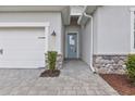 Welcoming front entrance features a light blue door, brick-paved walkway, and manicured landscaping at 17620 Winding Wood Ln, Punta Gorda, FL 33982
