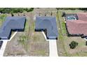 Aerial view of a home with a dark roof and a long driveway on a sunny day in a residential area at 18503 Ellen Ave, Port Charlotte, FL 33948