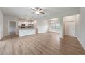 Open-concept living room featuring wood-look floors, ceiling fan, and an adjacent kitchen and dining area at 18503 Ellen Ave, Port Charlotte, FL 33948