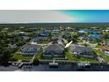 Home with screened pool and dock access to the waterway, surrounded by lush green landscaping at 19246 Moore Haven Ct, Port Charlotte, FL 33948