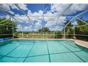 Relaxing screened-in pool area with serene views of the surrounding green space and blue skies at 2193 Beacon Dr, Port Charlotte, FL 33952