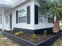 Well-maintained home exterior features black trim, black shutters and a decorative palm tree at 230 Waterway Cir Ne, Port Charlotte, FL 33952