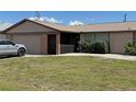 Cozy single-story home with an attached garage, screened porch and manicured lawn at 23269 Lehigh Ave, Port Charlotte, FL 33954