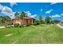 Inviting home exterior boasts well-maintained landscaping, including palms, and a vibrant green lawn at 253 Marcheno Way, Nokomis, FL 34275