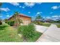 Beautiful home exterior showcasing lush landscaping, including palms, and a long driveway leading to an attached garage at 253 Marcheno Way, Nokomis, FL 34275