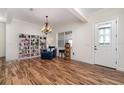 Bright living room showcasing wood floors, decorative chandelier, bookshelf and an adjacent entryway at 2707 Auburn Blvd, Port Charlotte, FL 33948