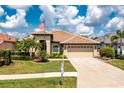 Beautiful single-story home featuring a tile roof, an attached two-car garage and manicured lawn at 2913 Royal Palm Dr, North Port, FL 34288