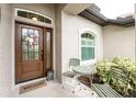 Inviting front entryway with a decorative wreath, quaint seating, and a 'Welcome' mat at 2913 Royal Palm Dr, North Port, FL 34288