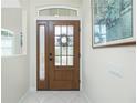 Inviting entryway showcasing a wood front door with glass panes, sidelight and transom window at 2913 Royal Palm Dr, North Port, FL 34288