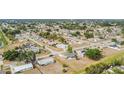 Expansive aerial view of a residential neighborhood featuring lush greenery and neatly arranged homes under a clear sky at 3342 Avanti Cir, North Port, FL 34287