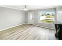 Bright living room with laminate floors, a decorative fireplace, and a large window offering a pleasant street view at 3342 Avanti Cir, North Port, FL 34287