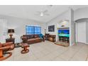 Comfortable living room features a leather sofa, tiled floor, and a ceiling fan for a cozy atmosphere at 3647 Culpepper Ter, North Port, FL 34286