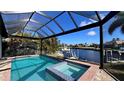 Relaxing screened-in pool and spa overlooking serene canal with dock and lift at 432 Gun Cay Ln, Punta Gorda, FL 33950
