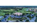 Expansive aerial view of community clubhouse, golf course and surrounding homes, with mature trees and water features at 5461 White Ibis Dr, North Port, FL 34287