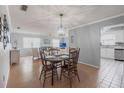 Cozy dining room with wood floors, and chandelier adjacent to a well-lit living room and kitchen at 6070 80Th N St # 215, St Petersburg, FL 33709