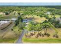 Aerial view of a sprawling estate with a pond, surrounded by lush greenery and mature trees at 6242 Tropicaire Blvd, North Port, FL 34291