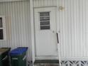 The mobile home entrance is secured with a sturdy white door featuring a window with a security view at 6832 Holo Ct, North Port, FL 34287