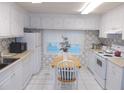 Charming kitchen with white cabinets, appliances, a small table with chairs, and plenty of sunlight at 6832 Holo Ct, North Port, FL 34287