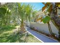 Exterior view showcasing the home's manicured lawn, tropical landscaping, and charming coastal curb appeal at 809 Kings Ct, Punta Gorda, FL 33950
