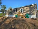 Home's rear entrance with a well-maintained yard and clear sky at 15431 Orangeade Dr, Punta Gorda, FL 33955