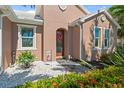 Inviting front entrance with decorative wreath, tile walkway, and beautiful flowerbeds at 16232 Quesa Dr, Punta Gorda, FL 33955