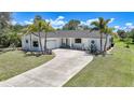 Attractive single-story home with lush landscaping, a curved driveway and an attached garage for convenience at 16615 Acapulco Rd, Punta Gorda, FL 33955