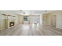 Bright living room with modern flooring, a fireplace, and large windows providing ample natural light at 16615 Acapulco Rd, Punta Gorda, FL 33955