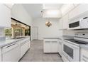 Bright kitchen featuring white appliances, ample counter space, and tile flooring at 18111 Lake Worth Blvd, Port Charlotte, FL 33948