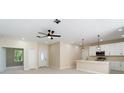 Spacious living room with a ceiling fan, bar, and views to the front door and dining area at 19092 Woodbine Ave, Port Charlotte, FL 33954