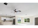 Bright living room with modern fan, recessed lighting, and view to the backyard at 19092 Woodbine Ave, Port Charlotte, FL 33954