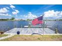 Private wooden dock on the water features an American flag and bench, perfect for enjoying waterfront views at 211 E Tarpon Nw Blvd, Port Charlotte, FL 33952