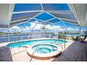 Inviting covered pool and hot tub offer a relaxing outdoor experience with views of the waterway at 211 E Tarpon Nw Blvd, Port Charlotte, FL 33952