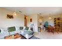 Inviting living room with a comfortable sectional sofa, bright lighting, and a seamless transition to the dining area at 2142 Gerard Ct, Port Charlotte, FL 33952