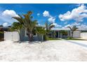 Cozy single-story home featuring well-kept landscaping, a light blue exterior, and bright blue skies at 21812 Edgewater Dr, Port Charlotte, FL 33952