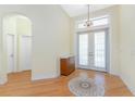 Bright foyer featuring hardwood floors, chandelier, and double doors leading outside at 233 Beeney Se Rd, Port Charlotte, FL 33952
