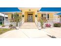 Charming home featuring a welcoming front entrance with white railing and meticulously landscaped yard at 233 Beeney Se Rd, Port Charlotte, FL 33952