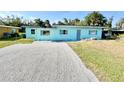 Inviting home with freshly graveled drive, light blue exterior, and well-kept lawn at 23476 Harper Ave, Punta Gorda, FL 33980