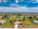 Expansive aerial view of a single-Gathering home with an enclosed backyard, outlined in red, set in a lush green community at 279 Mariner Ln, Rotonda West, FL 33947