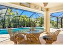 Cozy outdoor patio featuring comfortable seating and a serene view of the sparkling pool and lush greenery at 279 Mariner Ln, Rotonda West, FL 33947