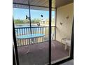 A cozy screened-in patio with a table and chairs overlooks a serene lake, inviting relaxation and outdoor enjoyment at 4056 Oakview Dr # E10, Port Charlotte, FL 33980