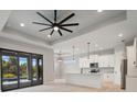 Bright, open-concept living space boasts stylish light fixtures and leads to a modern kitchen and sliding glass doors at 7149 Sea Mist Dr, Port Charlotte, FL 33981
