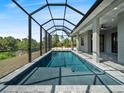 Beautiful screened-in pool with patio offers a serene outdoor living space and unobstructed views of the natural surroundings at 7149 Sea Mist Dr, Port Charlotte, FL 33981