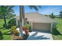 Attractive single-story home featuring tropical landscaping, lush lawn, and a two-car garage at 7505 Carissa, Punta Gorda, FL 33955