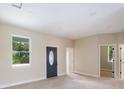 Bright entryway featuring a decorative front door, neutral paint, and wood-look tile flooring at 8849 Attalla Ave, North Port, FL 34287
